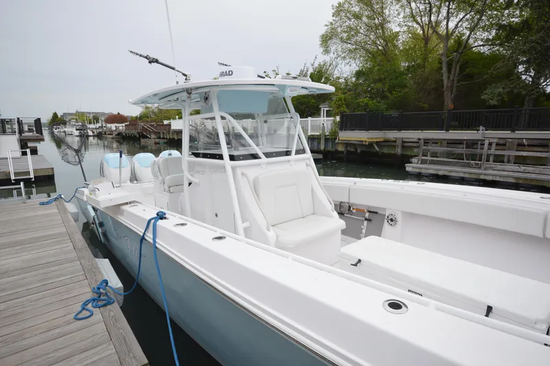 Slide: The Image of 2017 Fountain 38 Center Console boat docked at marina, featuring sleek design and spacious deck. - 7