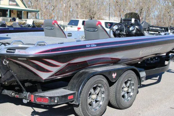 Slide: The Image of 2023 Phoenix 921 ELITE bass boat with dual axle trailer in a parking lot. - 19