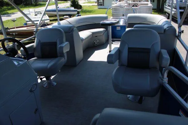 Slide: The Image of 2021 Lowe SS250 Super Sport pontoon boat interior with plush seating and steering console. - 10