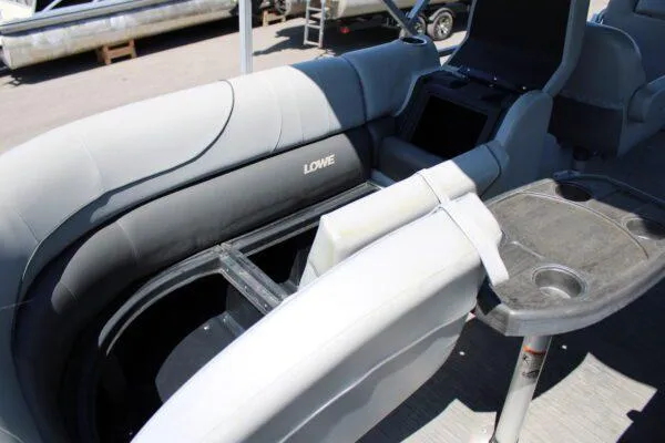 Slide: The Image of 2021 Lowe SS250 Super Sport boat interior with gray seating and table. - 12