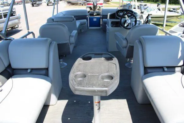 Slide: The Image of 2021 Lowe SS250 Super Sport pontoon boat interior with gray seating and central table. - 15