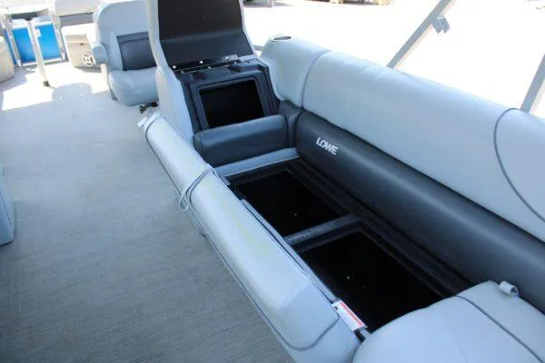 Slide: The Image of 2021 Lowe SS250 Super Sport boat with open storage compartments and gray seating. - 9