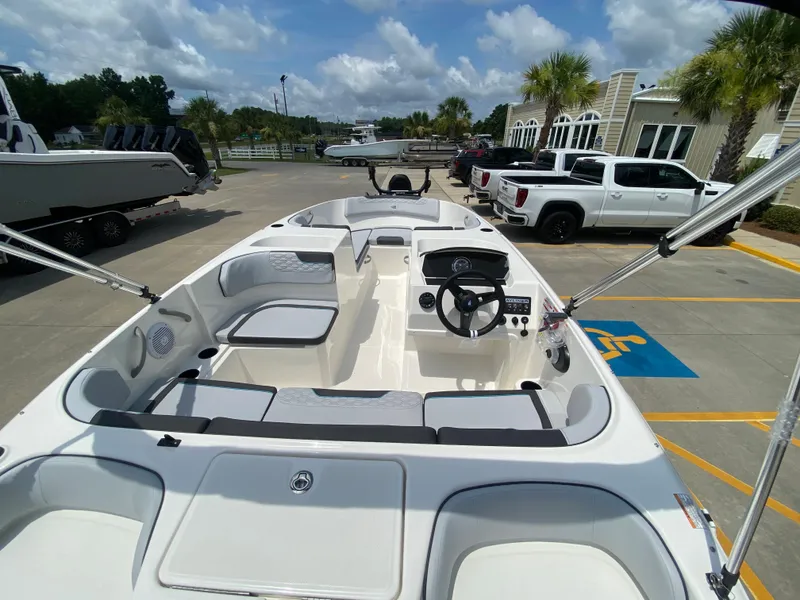 Slide: The Image of 2024 Bayliner Element M17 boat interior at a marina with parked vehicles. - 5