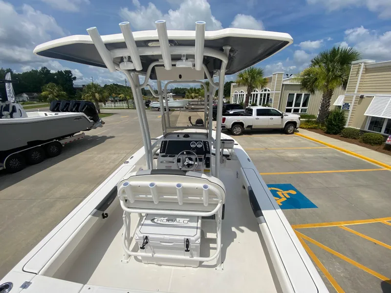 Slide: The Image of 2024 Robalo 226 Cayman boat with T-top and center console in a parking lot. - 5