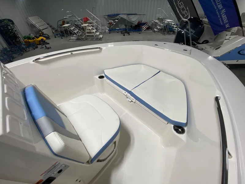 Slide: The Image of 2024 Robalo R180 Center Console boat interior with white and blue seating. - 11