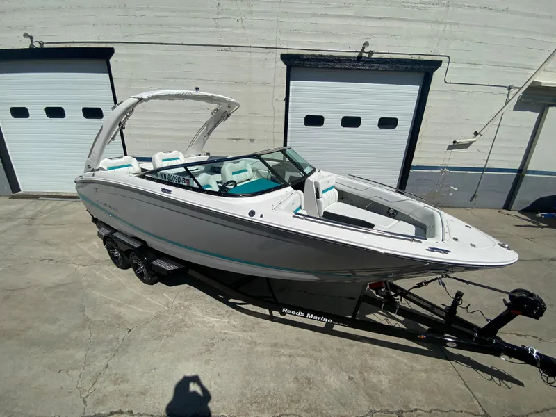 Slide: The Image of 2024 Regal LS6 boat on trailer outside garage doors. - 2