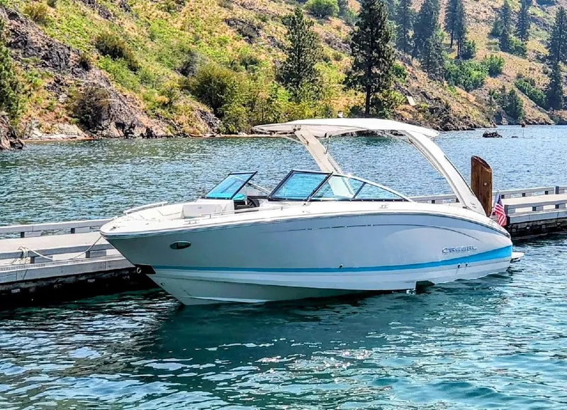 Slide: The Image of 2024 Regal LS6 boat docked on a scenic lake with lush hills. - 3