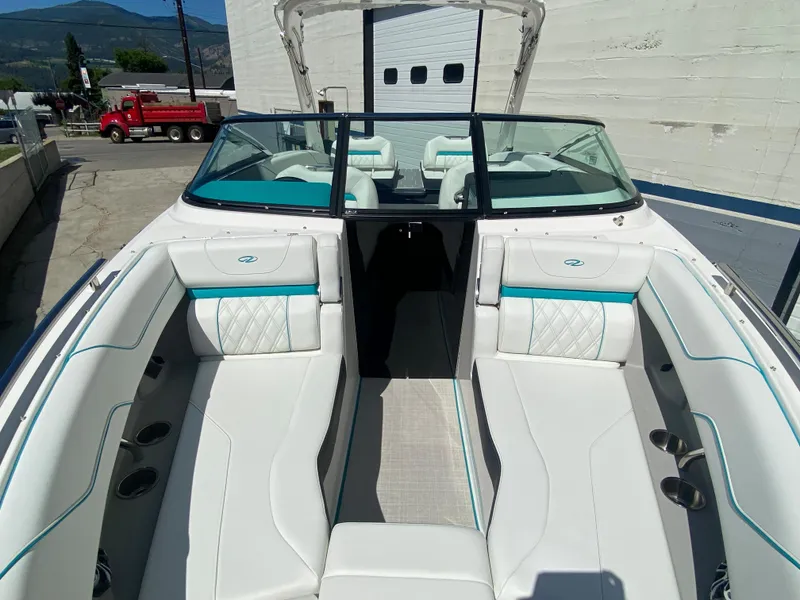 Slide: The Image of 2024 Regal LS6 boat interior with white and teal seating, open bow, and windshield. - 5