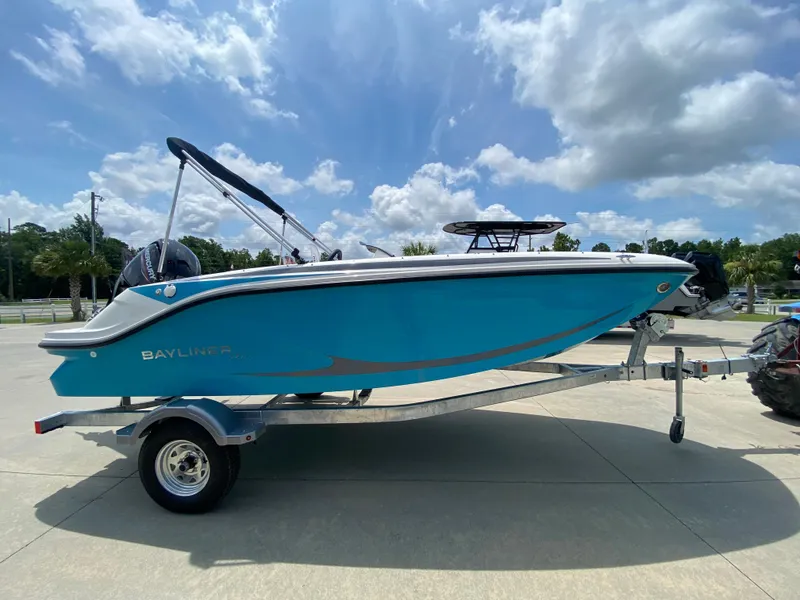 Slide: The Image of 2024 Bayliner Element M17 boat on a trailer under a partly cloudy sky. - 2