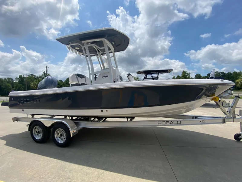 Slide: The Image of 2024 Robalo 226 Cayman boat on a trailer under a blue sky. - 2