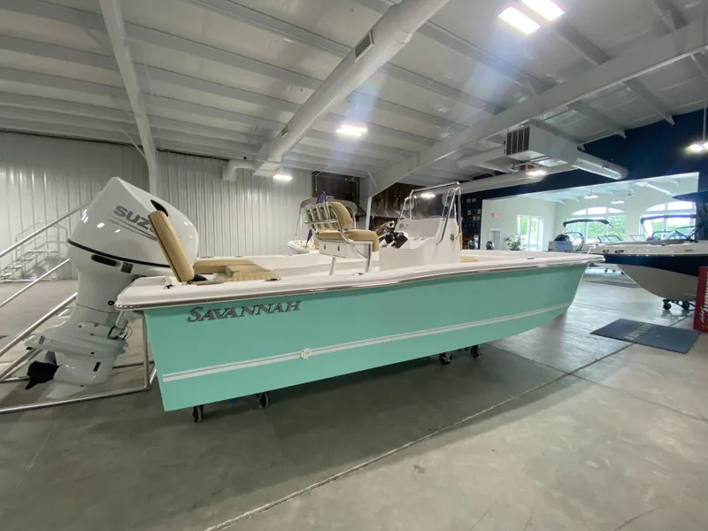 Slide: The Image of 2024 Savannah SS19 boat in showroom with Suzuki outboard motor. - 1
