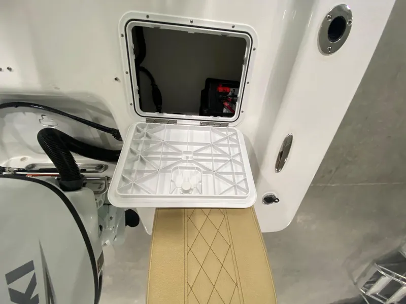 Slide: The Image of 2024 Savannah SS19 boat storage compartment with open hatch and beige cushioned seat. - 10