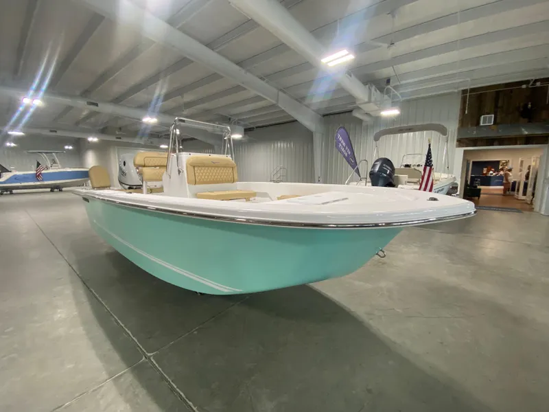 Slide: The Image of 2024 Savannah SS19 boat in showroom, mint green hull, beige seating. - 3