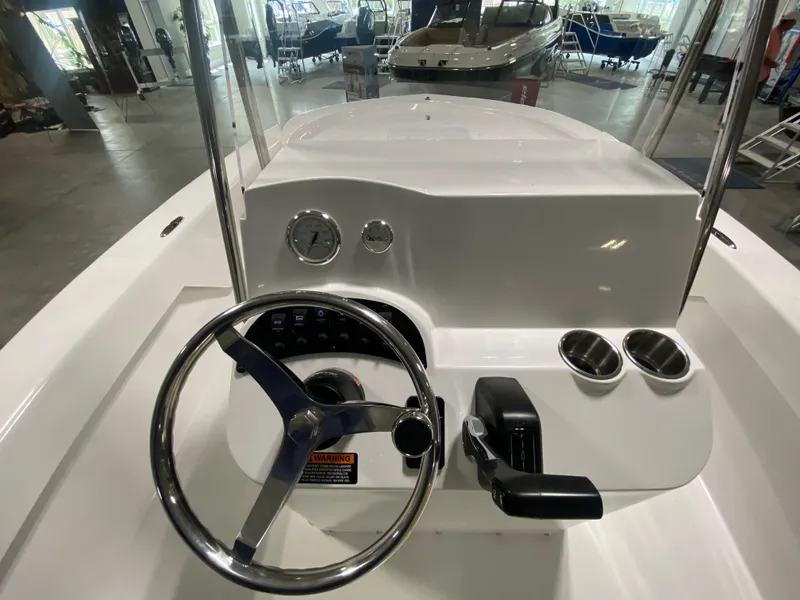 Slide: The Image of 2024 Savannah SS19 boat console with steering wheel and controls in showroom. - 13