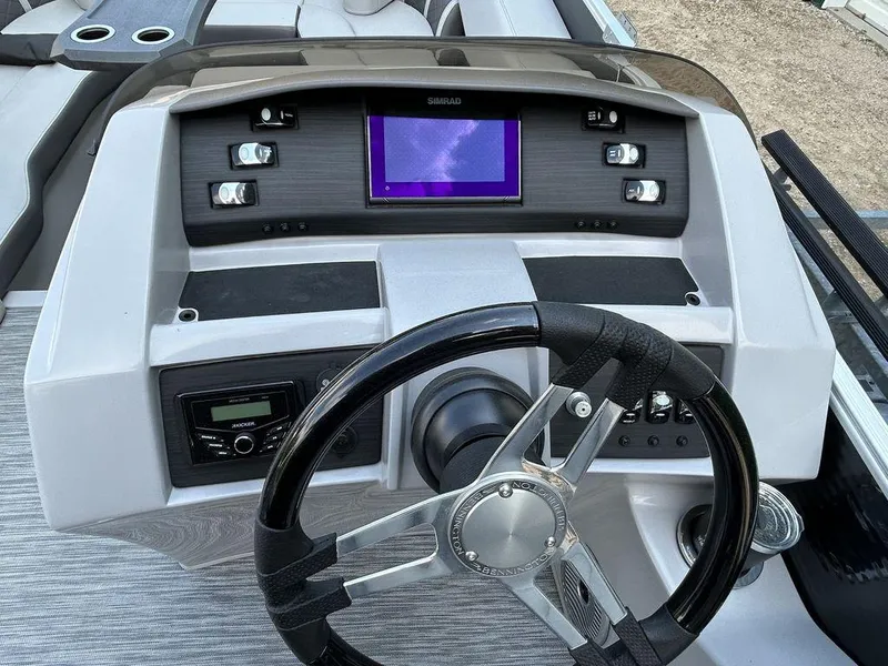 Slide: The Image of 2022 Bennington L25 boat dashboard with steering wheel and electronic controls. - 4