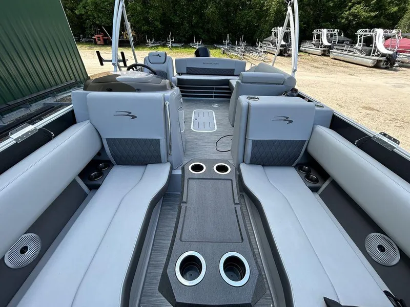 Slide: The Image of 2022 Bennington L25 pontoon boat interior with gray seating and cup holders. - 7