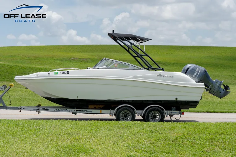Slide: The Image of 2020 Hurricane 217 SD boat on trailer, side view, green field background. - 8