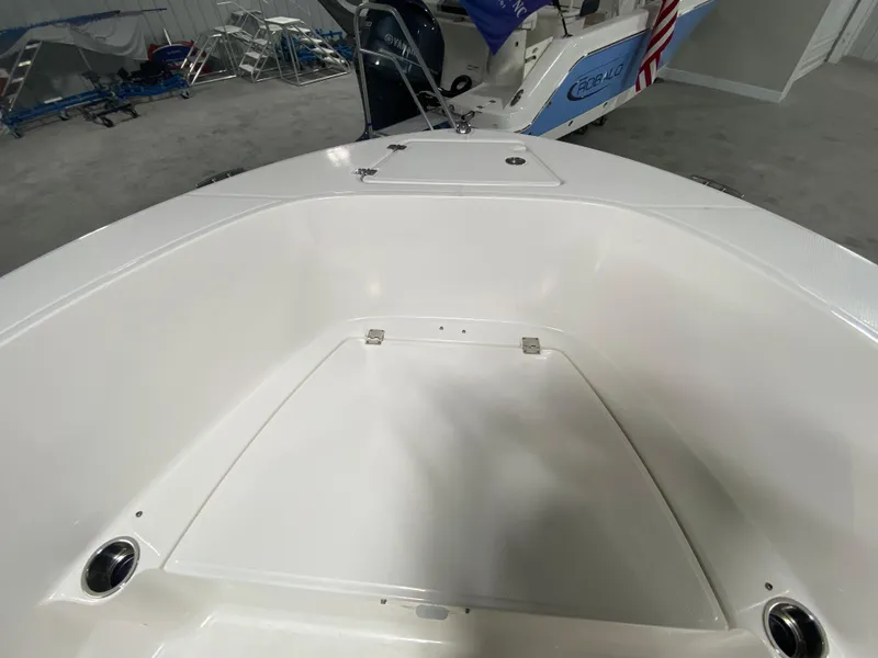 Slide: The Image of 2024 Robalo R180 Center Console boat interior, white seating area and storage compartment. - 16