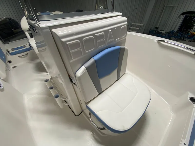 Slide: The Image of 2024 Robalo R180 Center Console boat interior with white and blue seating. - 13
