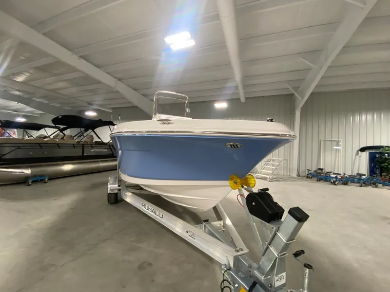 Slide: The Image of 2024 Robalo R180 Center Console boat on a trailer in a showroom. - 3