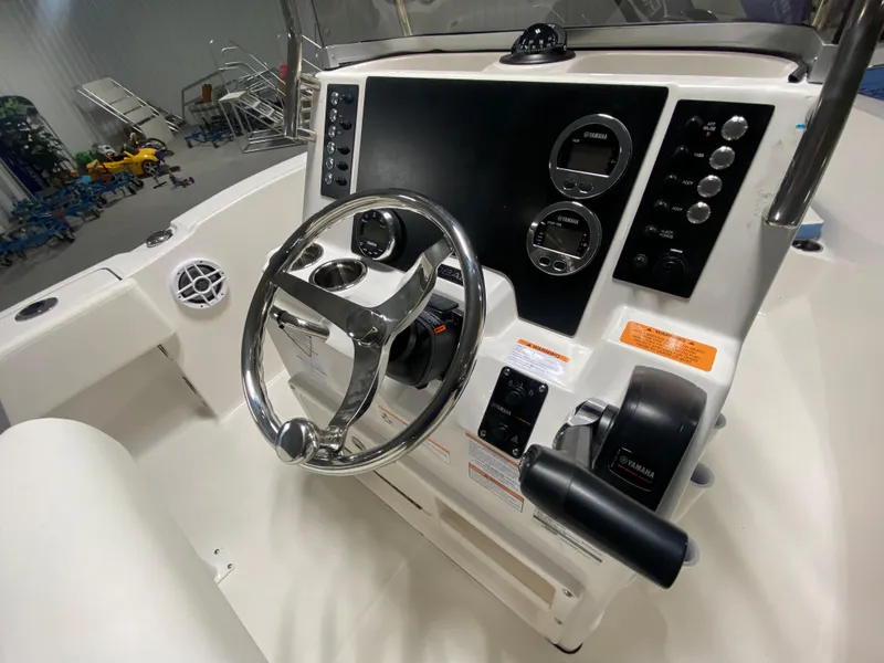 Slide: The Image of 2024 Robalo R180 Center Console boat dashboard with steering wheel and controls. - 9