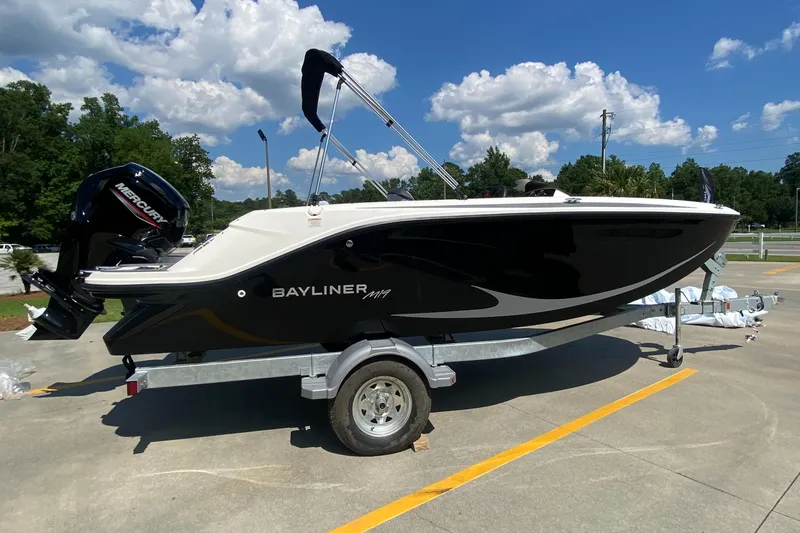 Slide: The Image of 2024 Bayliner Element M19 boat on a trailer under a blue sky. - 3