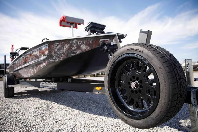 Slide: The Image of 2023 Go-Devil 2060 boat on trailer with Continental tire, gravel ground, and blue sky. - 4