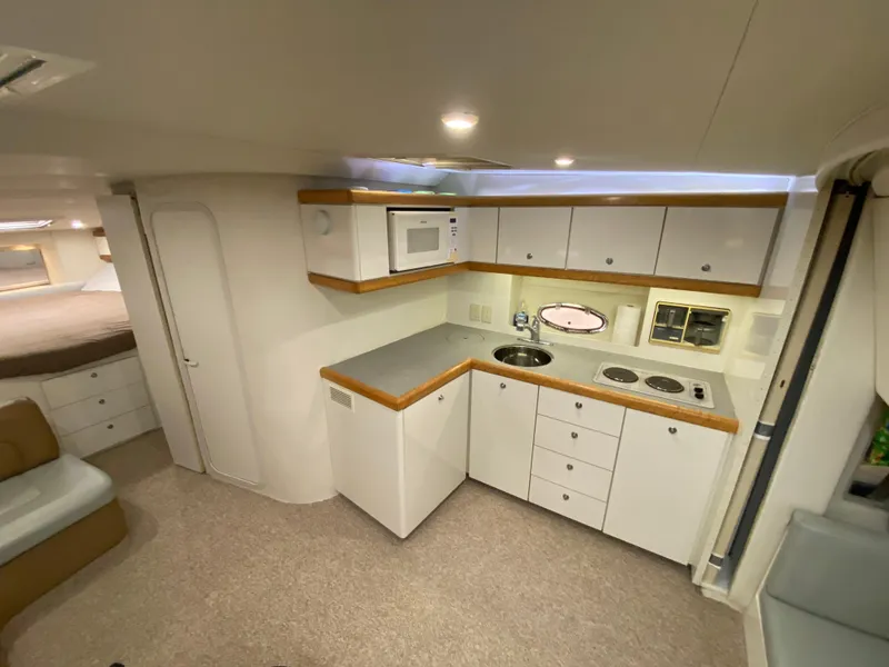 Slide: The Image of Interior of 1996 Carver 390 Express yacht featuring a compact kitchen with modern amenities. - 19