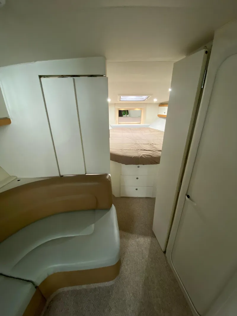 Slide: The Image of Interior of 1996 Carver 390 Express yacht, featuring a cozy cabin with seating and bed. - 25