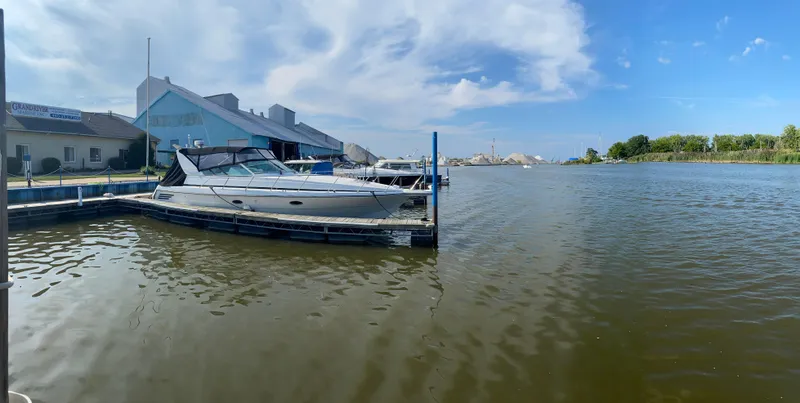 Slide: The Image of 1996 Carver 390 Express docked at a marina under a clear blue sky. - 3