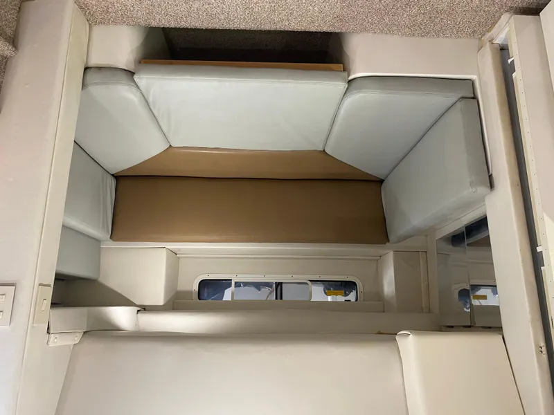 Slide: The Image of Interior seating area of a 1996 Carver 390 Express boat, featuring cushioned benches. - 35