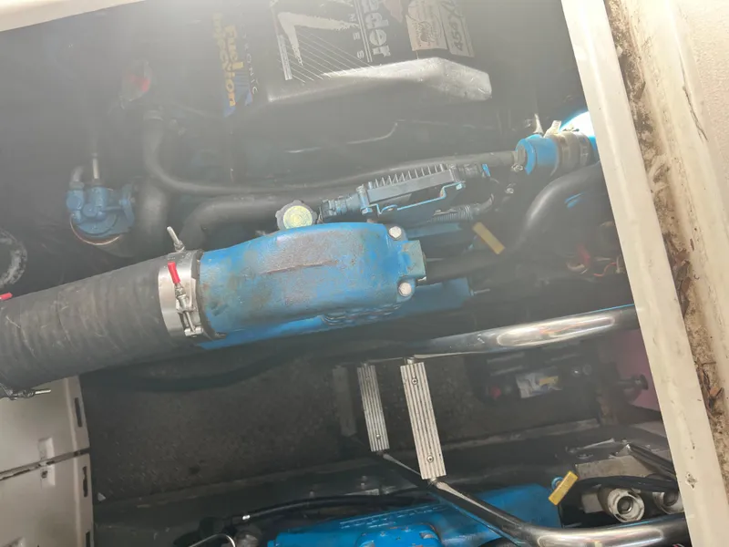 Slide: The Image of Engine compartment of a 1996 Carver 390 Express boat, featuring blue components and hoses. - 40