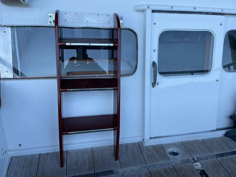 Slide: The Image of 1961 Chris-Craft Conqueror boat with wooden ladder and white cabin door. - 11