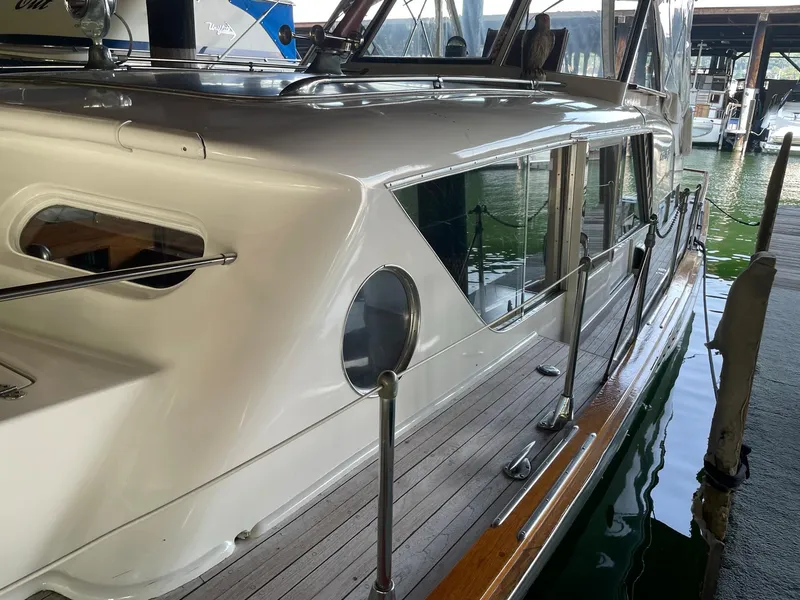 Slide: The Image of 1961 Chris-Craft Conqueror boat docked, showcasing sleek design and polished wood deck. - 14