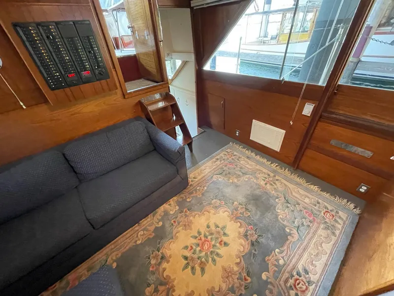 Slide: The Image of Interior of 1961 Chris-Craft Conqueror with sofa, floral rug, and wooden paneling. - 19