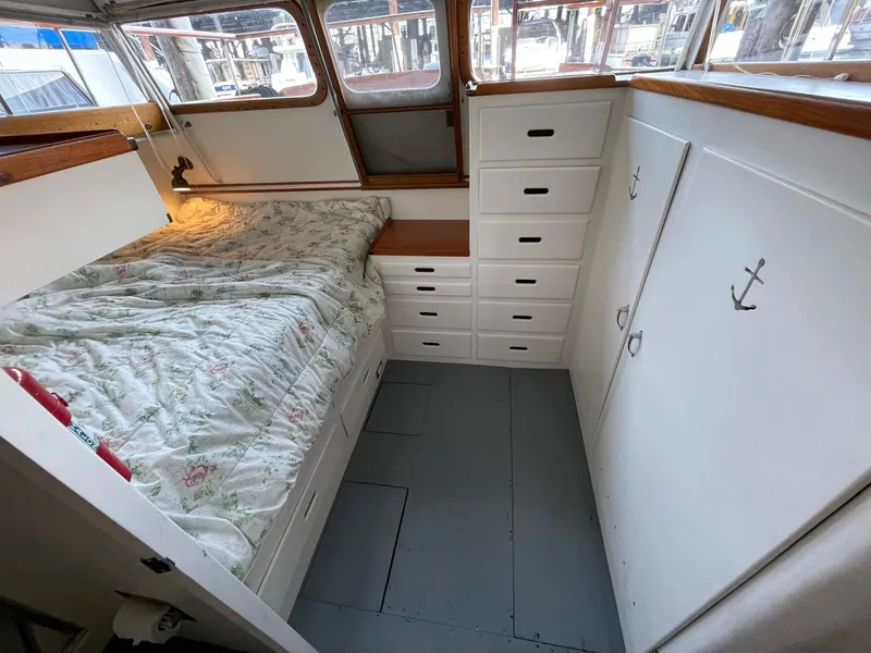 Slide: The Image of 1961 Chris-Craft Conqueror cabin interior with bed, drawers, and nautical decor. - 25