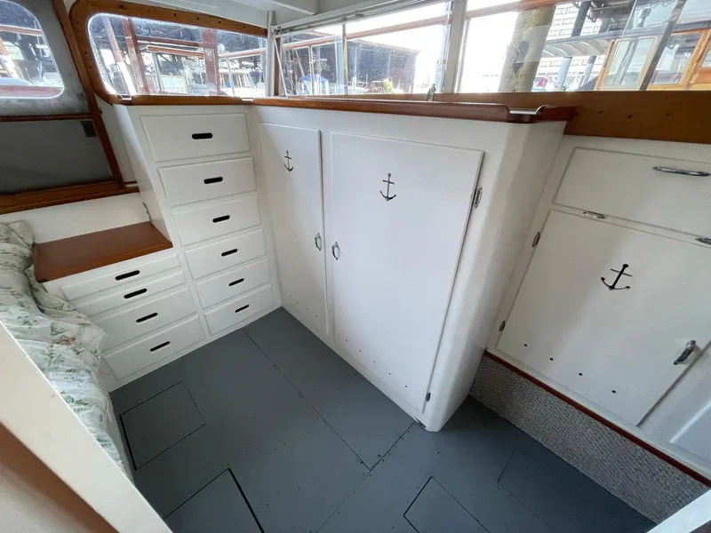 Slide: The Image of 1961 Chris-Craft Conqueror interior with white cabinets, anchor handles, and a cushioned bench. - 26