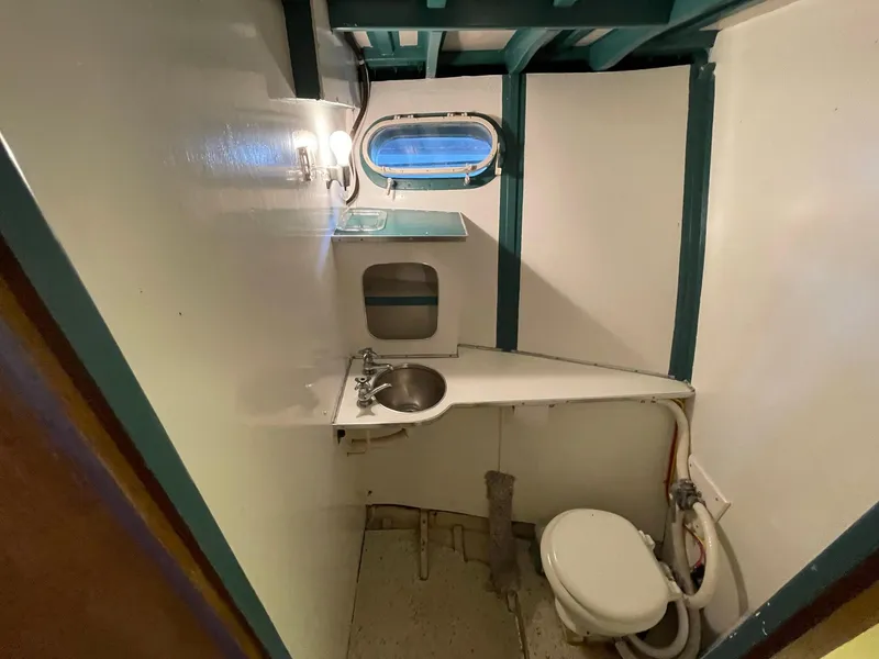 Slide: The Image of 1961 Chris-Craft Conqueror boat bathroom with sink, toilet, and porthole window. - 31