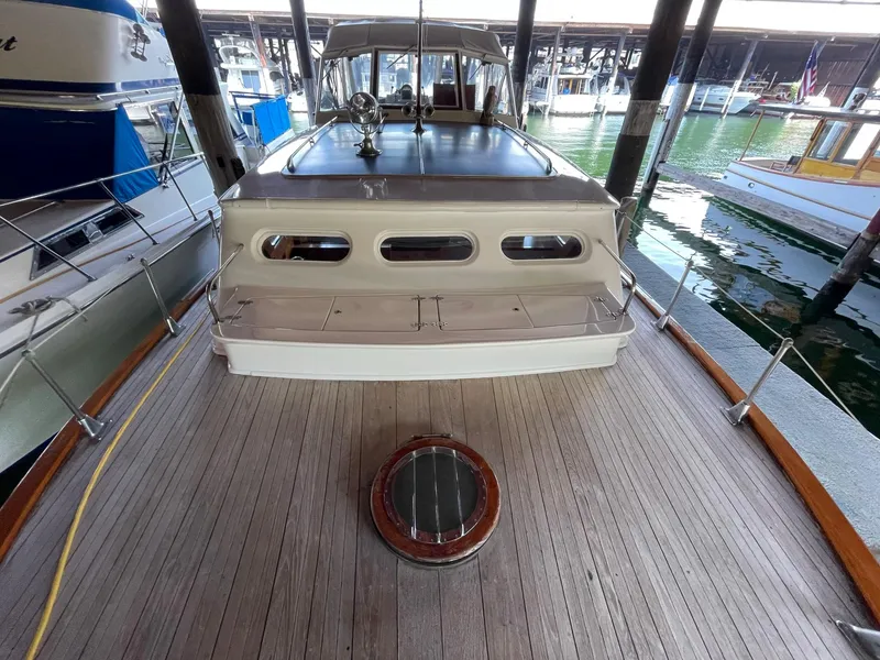 Slide: The Image of 1961 Chris-Craft Conqueror boat docked, showcasing wooden deck and classic design. - 35