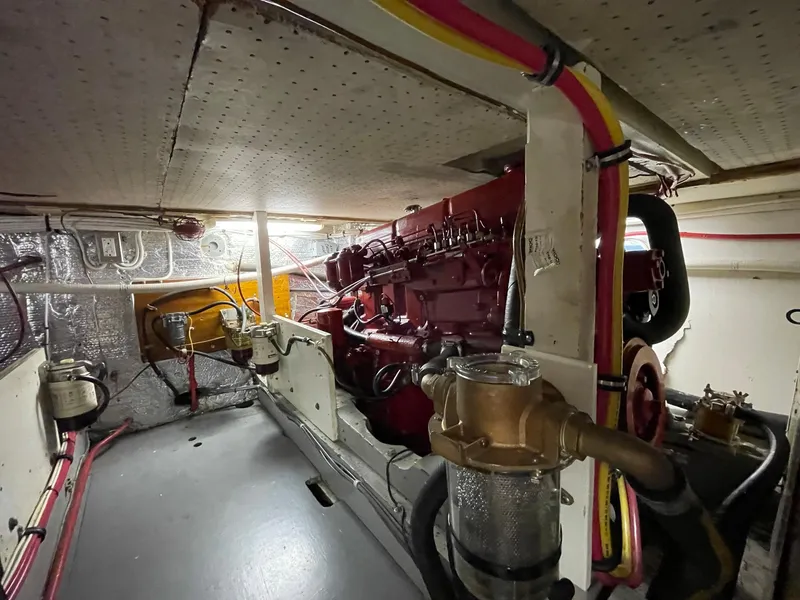 Slide: The Image of 1961 Chris-Craft Conqueror engine room with red engine and visible piping. - 43