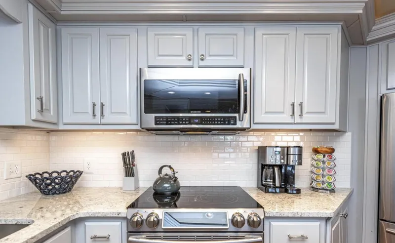 Slide: The Image of Modern kitchen with stainless steel appliances, white cabinets, and granite countertops in a 2007 Horizon 18 x 80. - 10