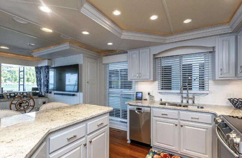 Slide: The Image of Modern kitchen in a 2007 Horizon 18 x 80 houseboat with granite countertops and stainless steel appliances. - 11