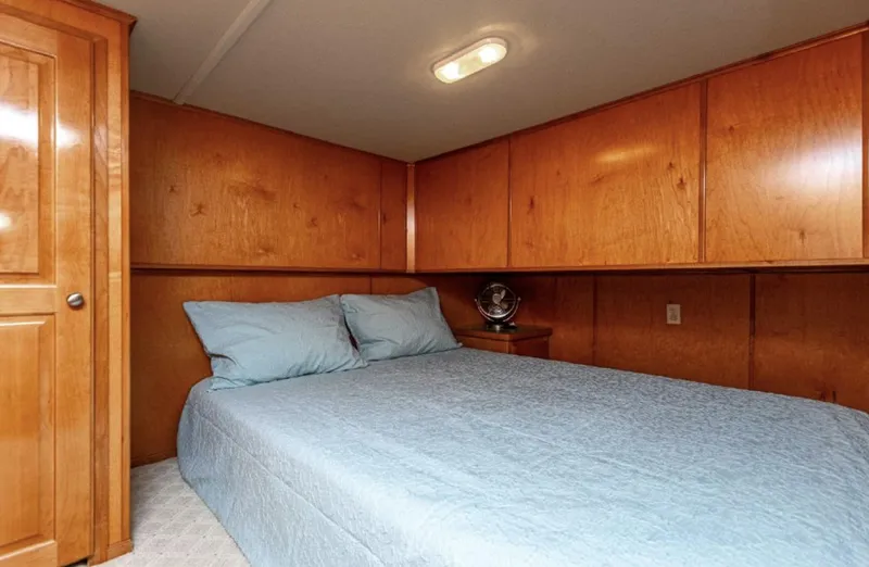 Slide: The Image of Cozy bedroom in a 2007 Horizon 18 x 80 houseboat with wooden cabinets and blue bedding. - 17