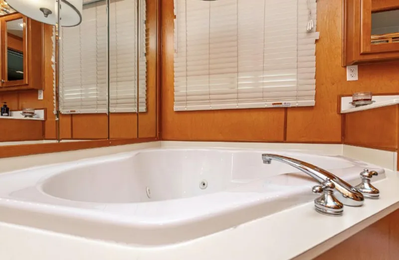 Slide: The Image of Luxurious bathtub in 2007 Horizon 18 x 80 houseboat with wooden paneling and mirrored walls. - 22