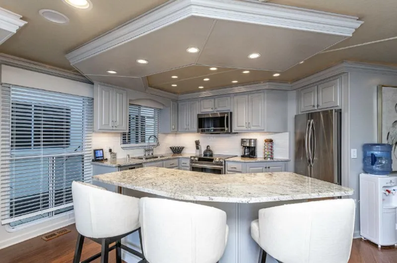 Slide: The Image of Modern kitchen in a 2007 Horizon 18 x 80 houseboat with granite countertops and stainless steel appliances. - 8