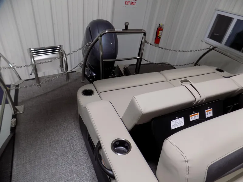 Slide: The Image of 2024 Barletta C22UC boat interior with beige seating and outboard motor. - 13