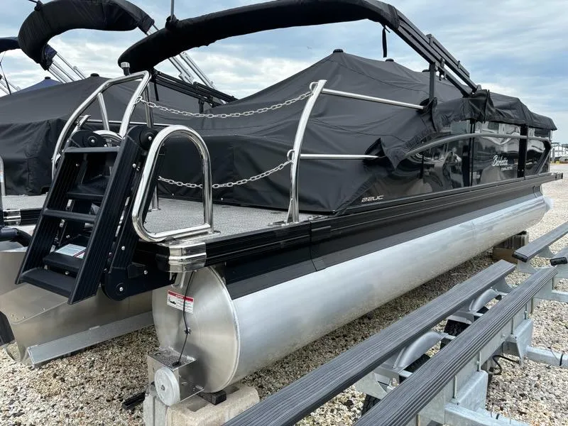 Slide: The Image of 2024 Barletta C22UC pontoon boat with black cover on trailer. - 2