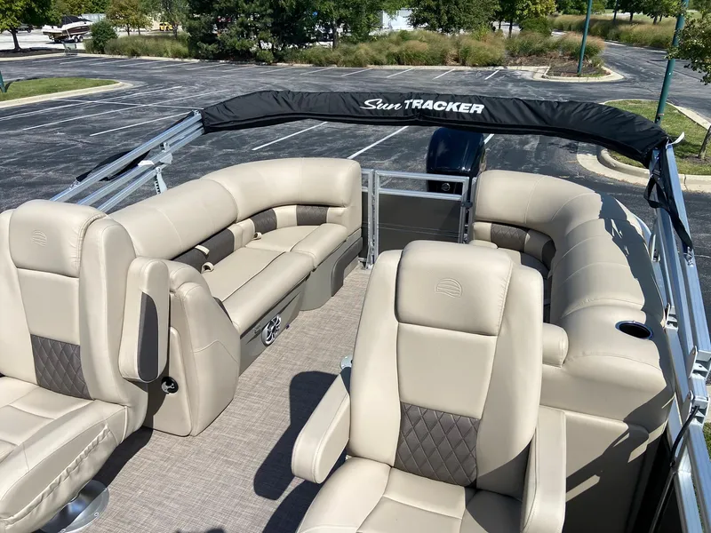 Slide: The Image of 2024 Sun Tracker Party Barge 22 DLX pontoon boat with beige seating and black canopy. - 3
