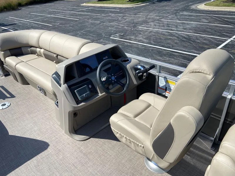 Slide: The Image of 2024 Sun Tracker Party Barge 22 DLX interior with beige seating and modern helm. - 4