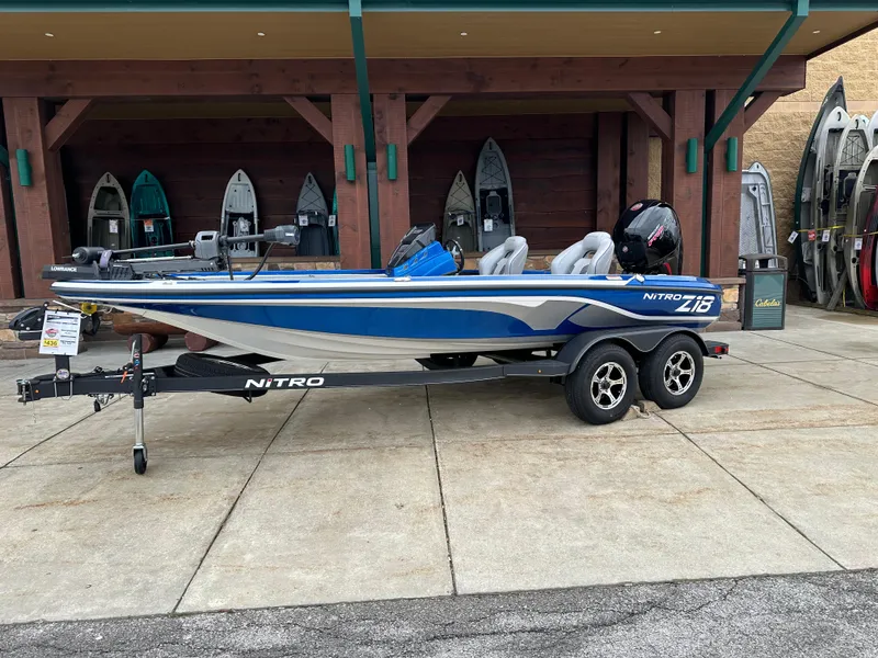 Slide: The Image of 2024 Nitro Z18 Pro fishing boat on trailer, blue and white, parked outside. - 0